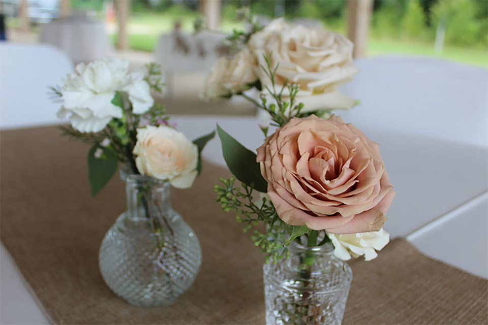 Pastel roses in crystal vases.